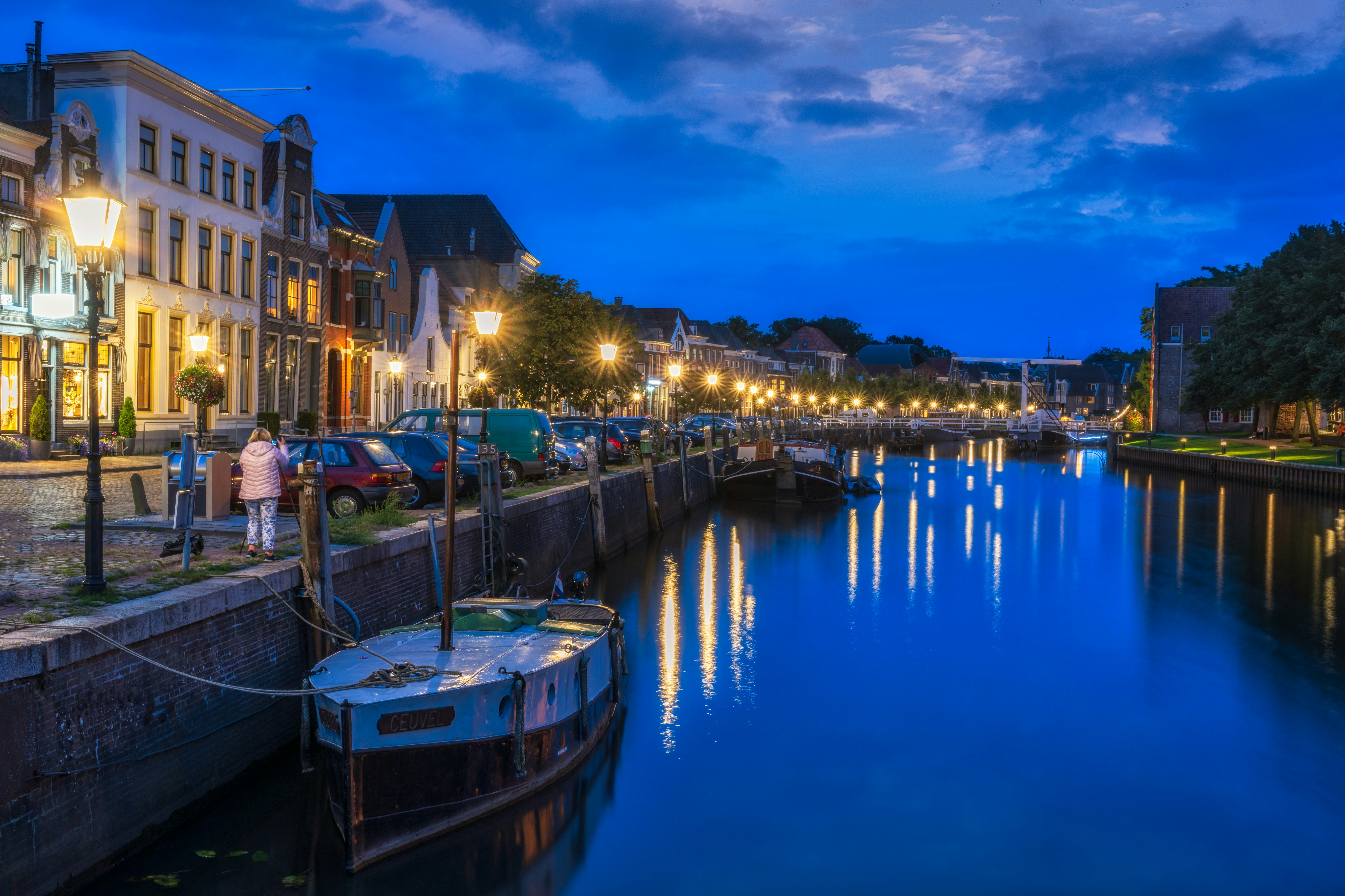 Zwolle's Thorbeckegracht canal at blue hour, lanterns reflecting in still water.